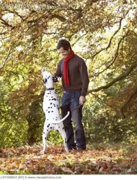 a_young_man_playing_with_his_dog_amongst_the_autumn_leaves_LV11598031.webp